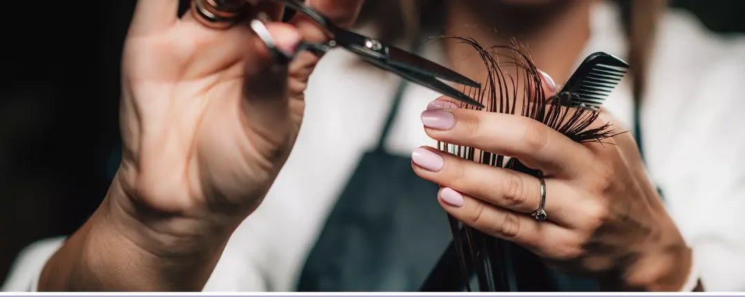 Coiffeuse coupant des cheveux aux ciseaux au salon Mickaël Piégay Coiffeur à Villeurbanne